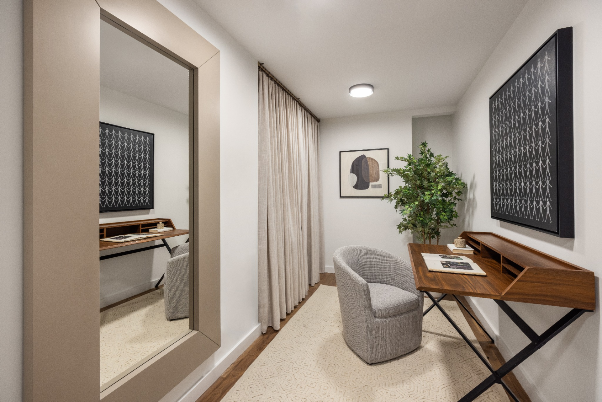 A wood desk is paired with a single upholstered chair and minimal shelving, keeping the layout uncluttered.