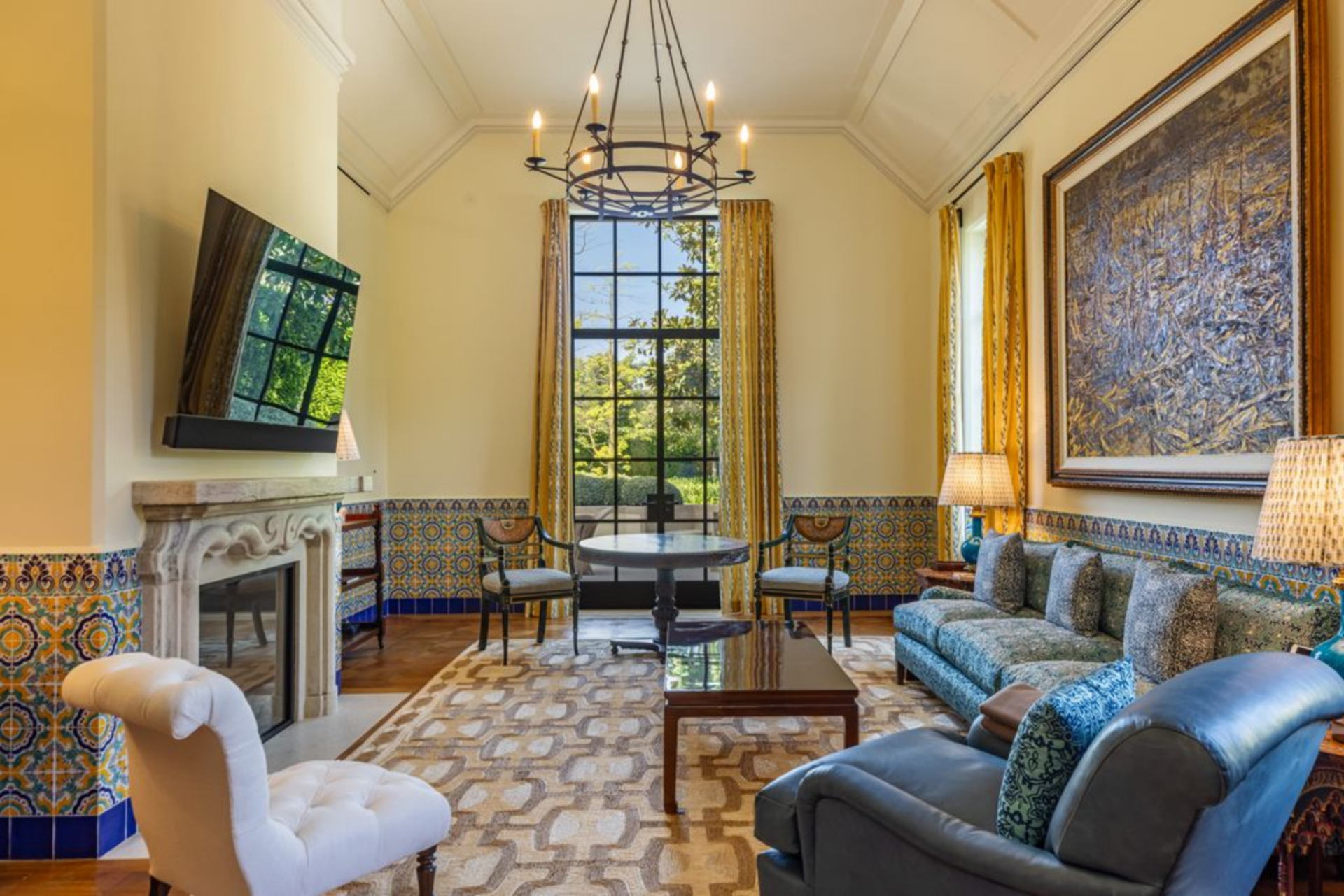 Seating faces a mounted screen above the mantel, creating a clear focal point for viewing, while a mix of sofas and chairs allows for flexible everyday use.