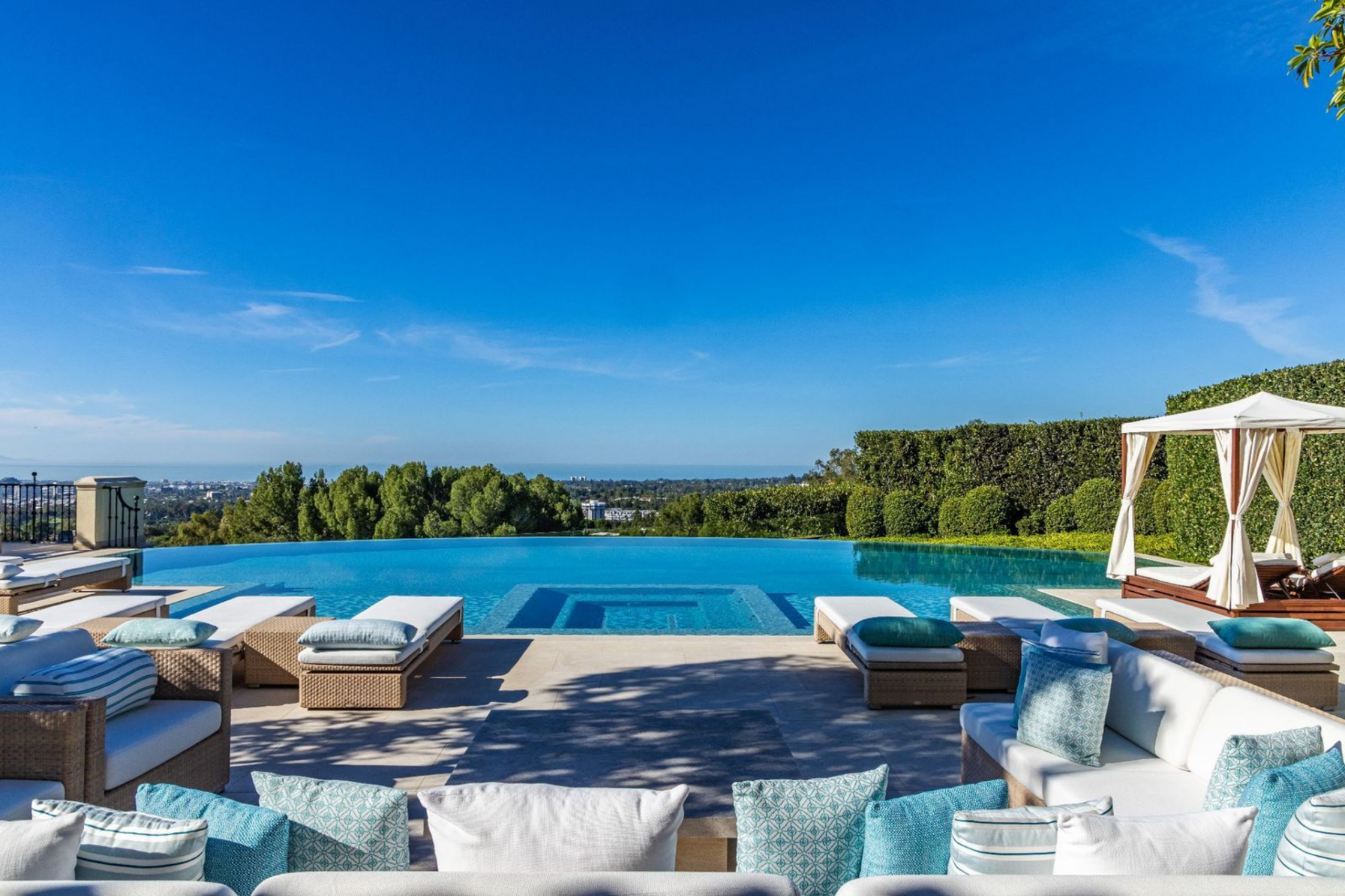 Near the guest house, a second pool takes on a more relaxed layout, anchored by an infinity edge that faces out over the surrounding greenery.