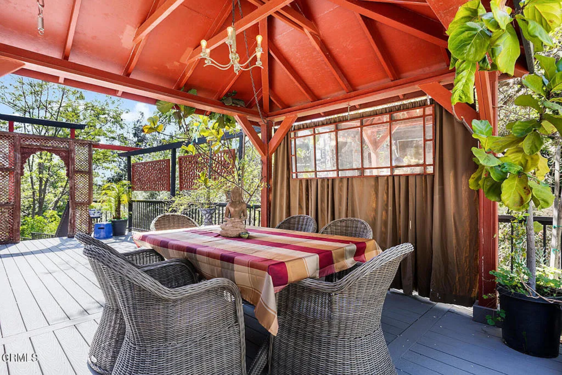 The deck extends outward with lattice panels and railing framing the edges, creating defined zones for dining and sitting without closing off the space.