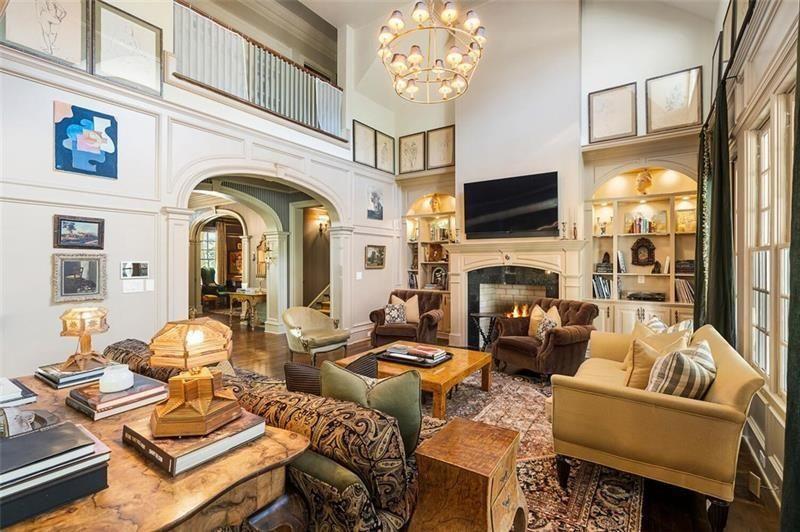 The soaring ceilings immediately change the scale of the interior, while upper-level gallery railings and tall transom windows bring in additional light from above.