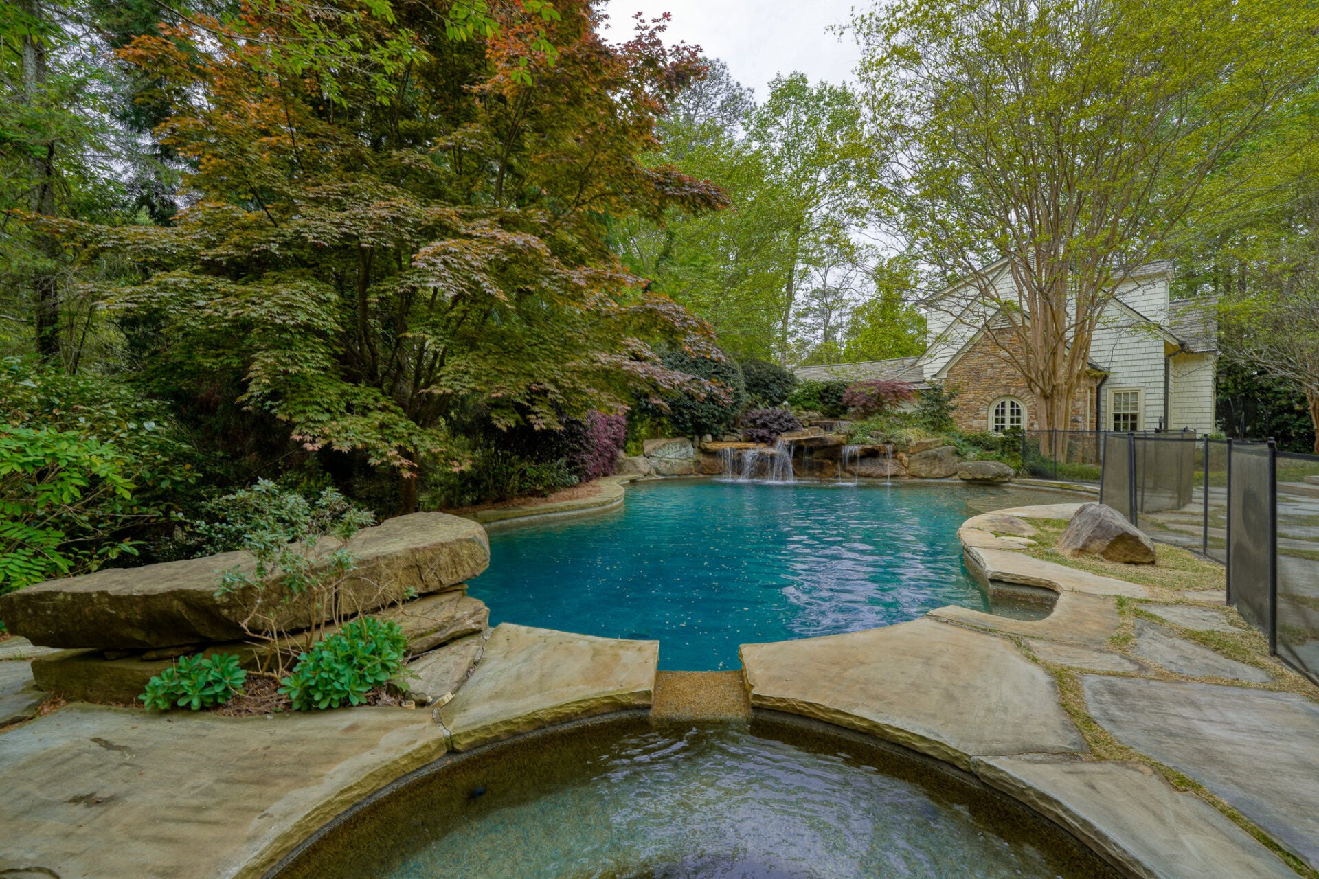 Outside, the backyard is centered around a heated resort-style pool and spa framed by natural stone terraces. 