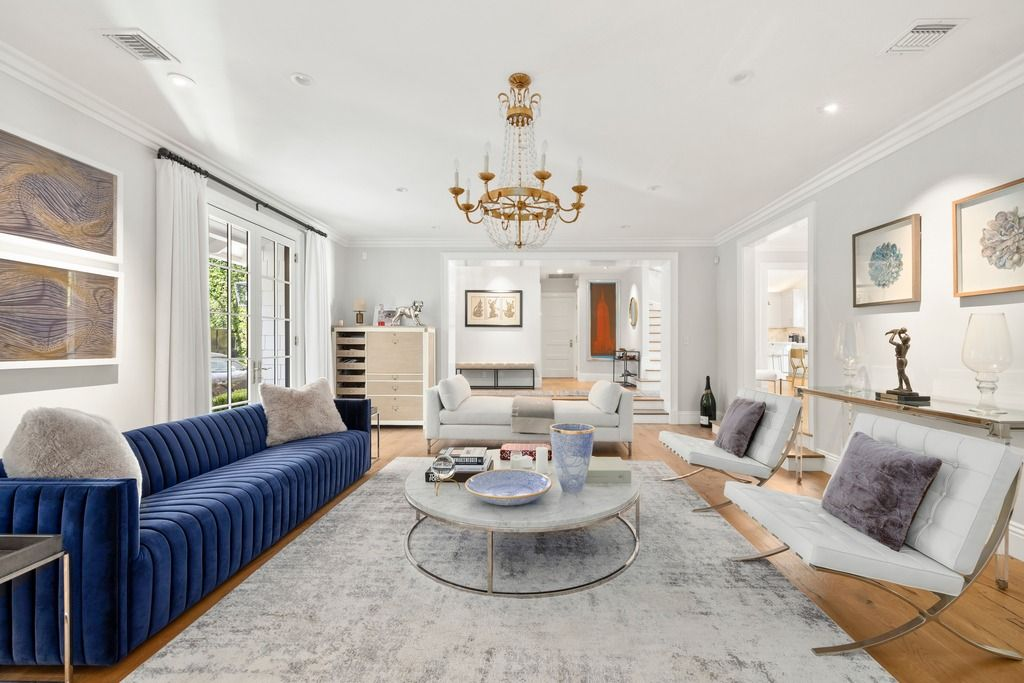 Walking into the house, the main living room opens up with high ceilings, European oak flooring, oversized windows, and French doors that pull in natural light.