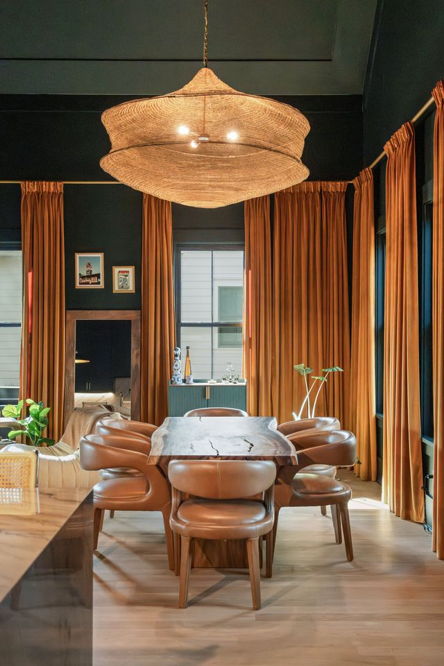 The dining setup itself leans into softer organic textures, pairing curved leather chairs with a wood-and-stone table that mirrors the natural materials used throughout the rest of the home.