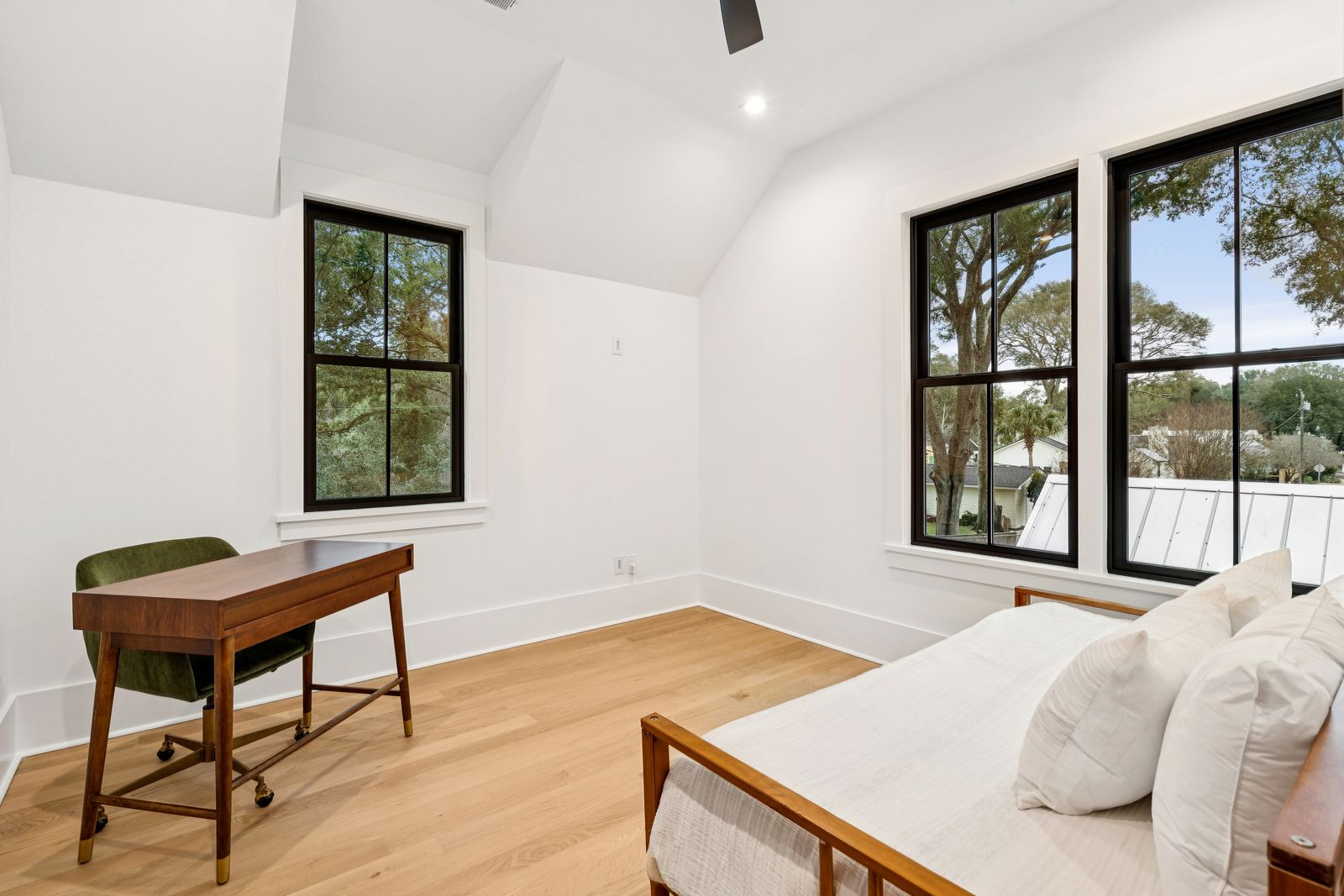 A quiet office or study with enough room for a desk and seating area beneath the angled ceilings.