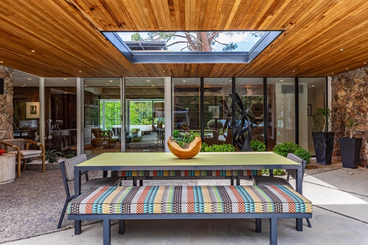 At one end of the courtyard is a covered outdoor dining patio positioned beneath a large skylight. Additionally, pebble-finished flooring, planted beds, and glass doors give the area the feel of an open-air atrium.
