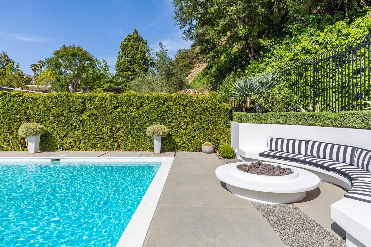 Curved built-in seating around the firepit create multiple gathering areas spread throughout the outdoor space