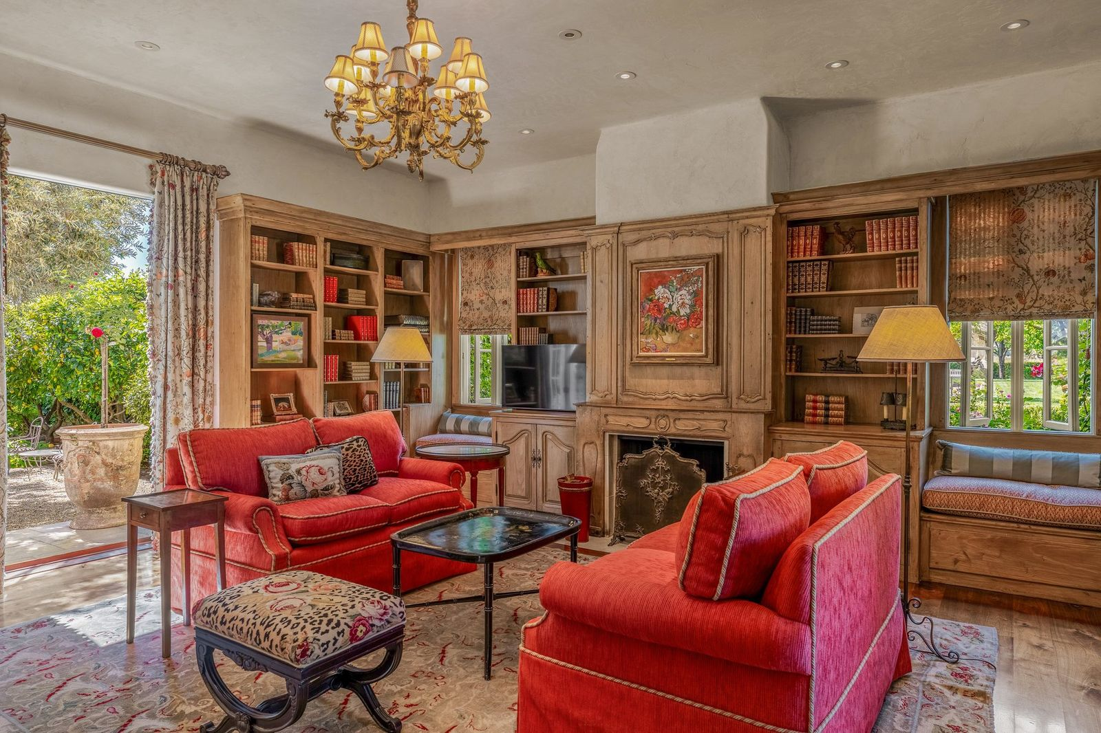Deep red seating adds warmth against the natural wood tones, creating a cozy reading and conversation space in addition to window benches built to overlook the gardens outside.