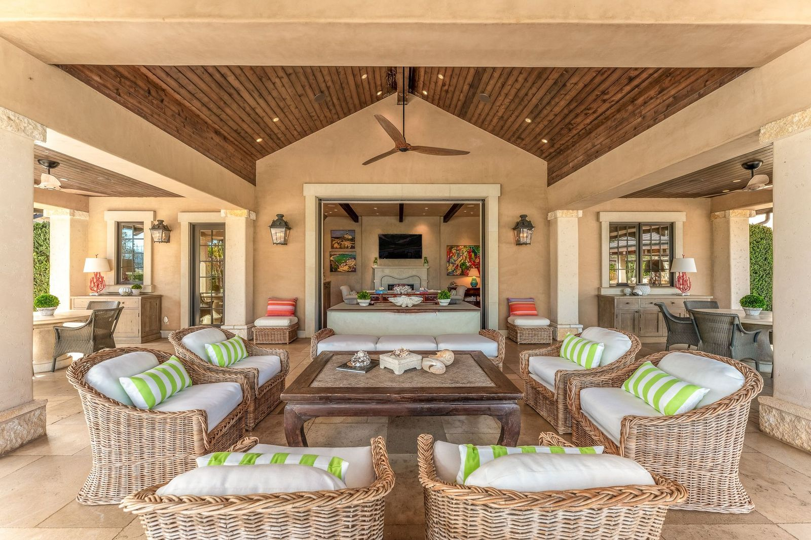 The separate pool house opens directly onto the outdoor entertaining spaces through large retractable doors that connect the interior lounge to the covered patio.