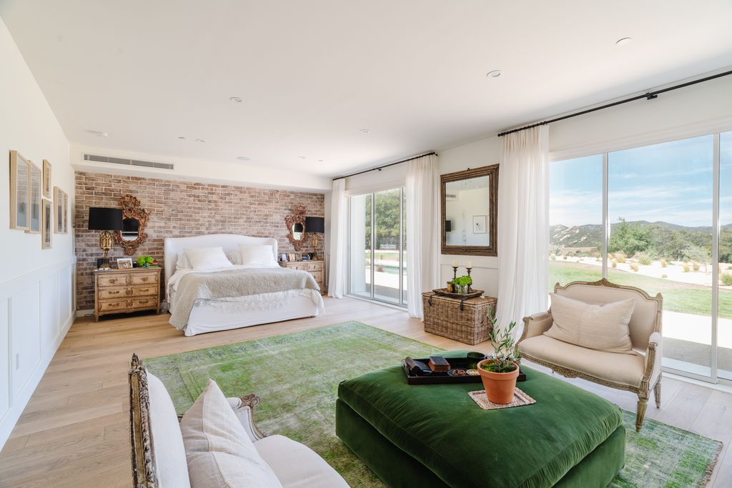 A brick accent wall sits behind the bed, adding texture and warmth against the bright palette.