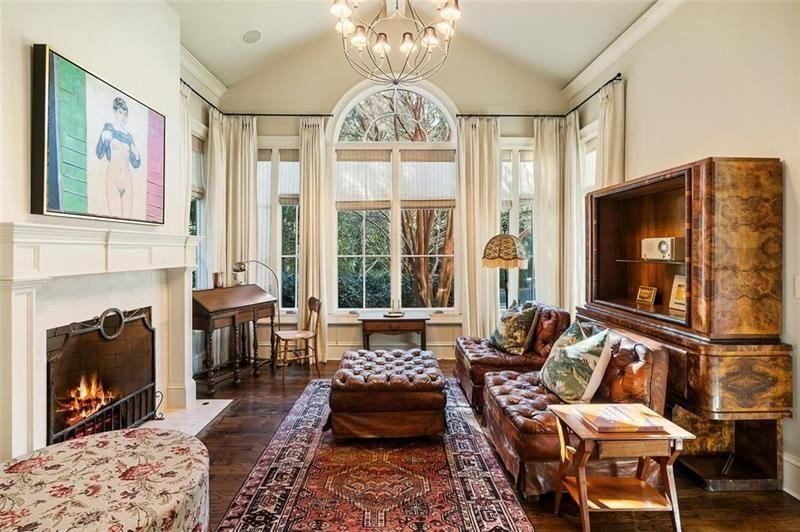 Connected directly to the bedroom is a separate lounge area centered around a fireplace and oversized arched window overlooking the trees outside. 