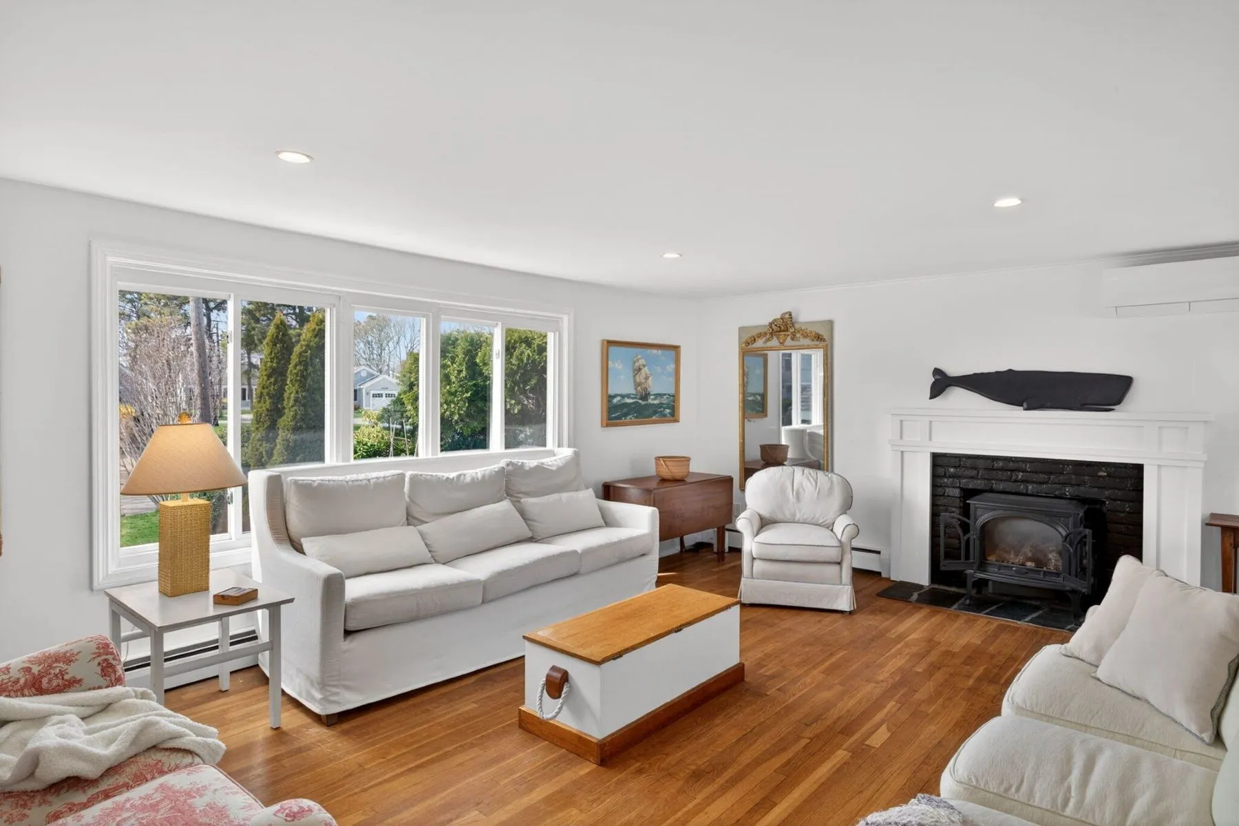 A black brick fireplace sits on one side of the room beneath a simple white mantel, while neutral slipcovered seating keeps the space casual and family-oriented rather than overly formal.