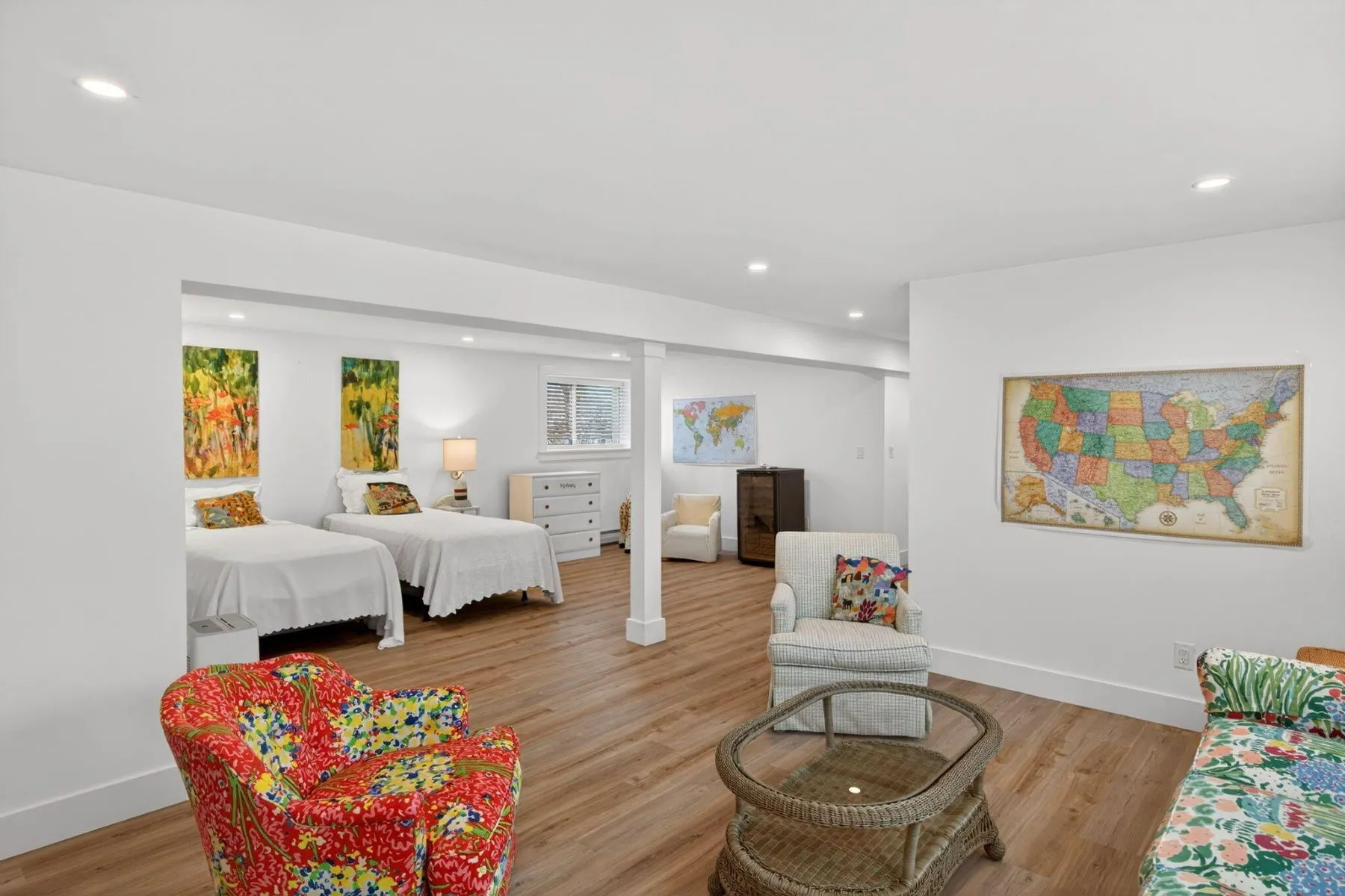 Two twin beds sit beneath colorful artwork.