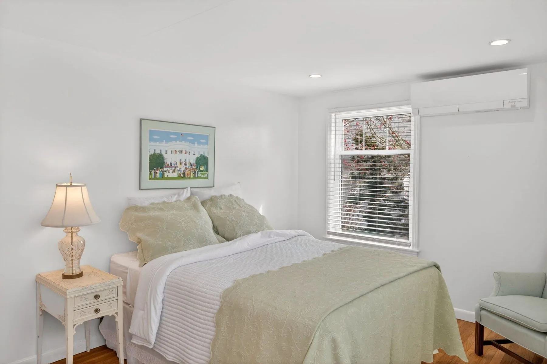 A final bedroom keeps things simple with soft green bedding, white walls, and simple furnishings. 