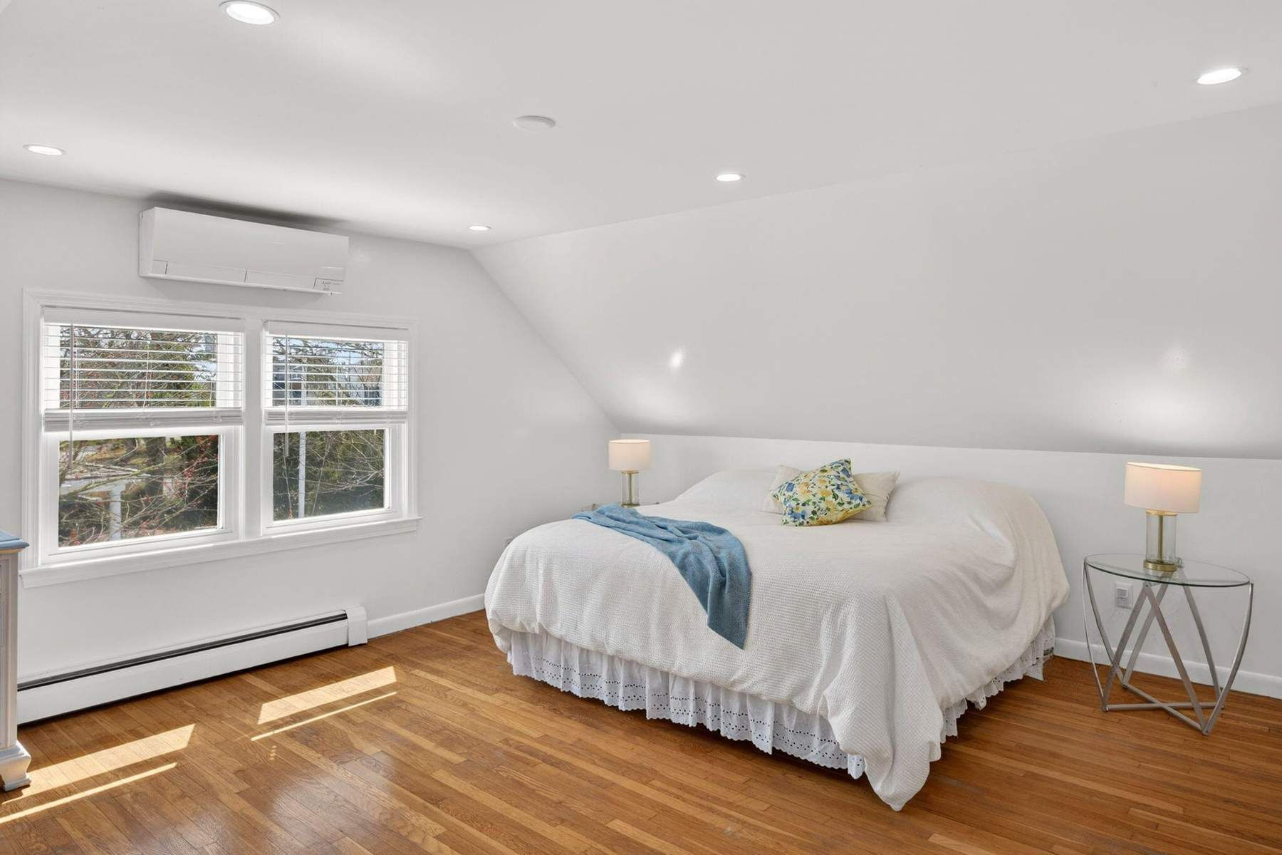 The final bedroom we want to highlight is the primary suite's bedroom, which is also set beneath a sloped ceiling with abundant natural light filling every corner of the room.