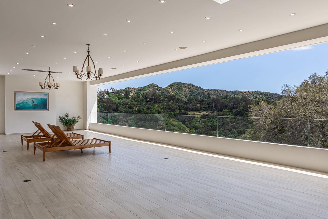 Sliding glass doors open the suite onto a long covered terrace overlooking the surrounding hillsides. 