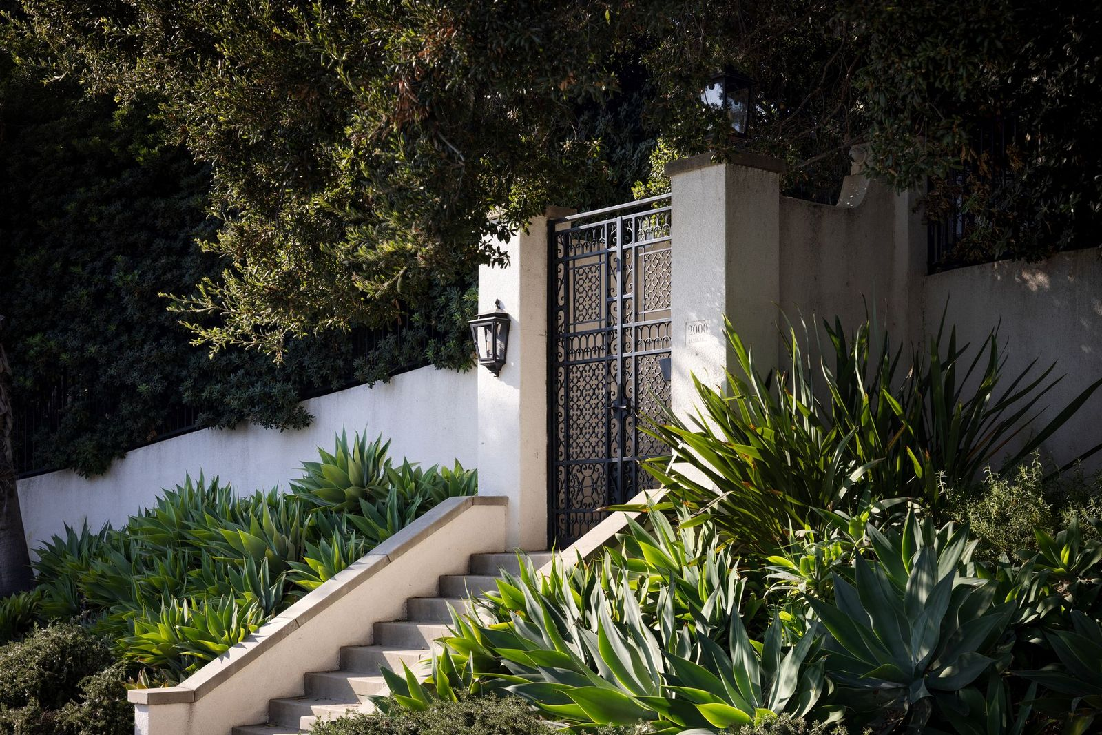 Gated entrance framed by greenery.