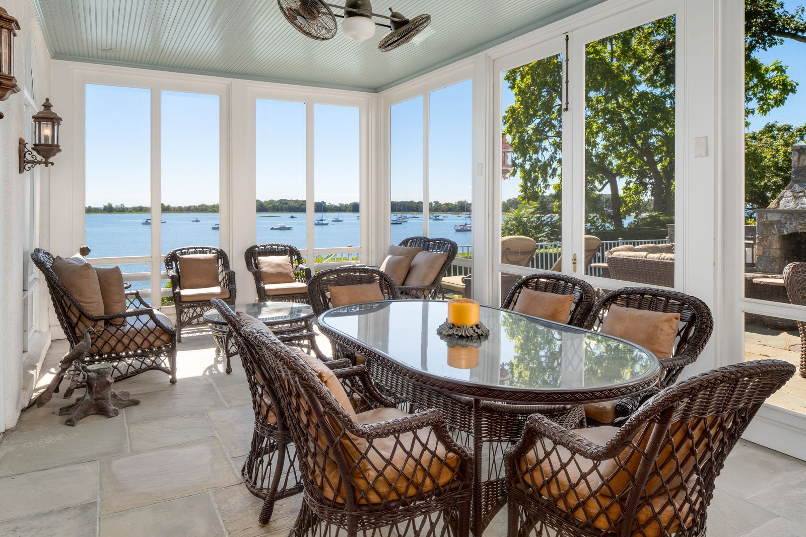 Woven seating and a large dining table give the porch the feel of a casual indoor-outdoor lounge.