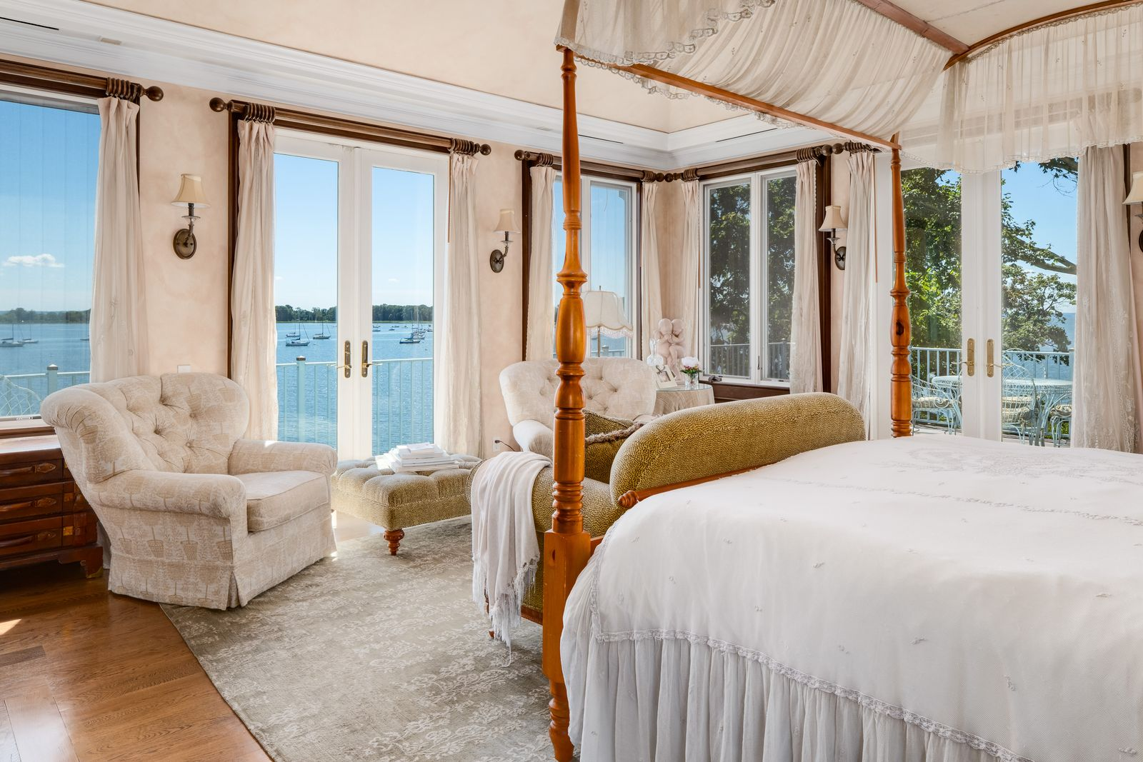 Soft neutral finishes and layered fabrics keep the space simple, while the surrounding water views remain the focal point from nearly every angle.