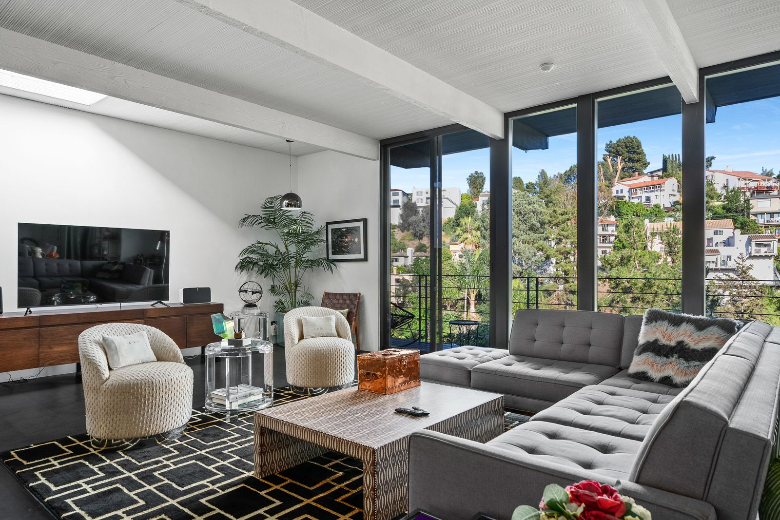 On the other side of the entrance’s stone wall, the living room opens into a dramatic double-height space framed by floor-to-ceiling glass arranged to maximize canyon views. 