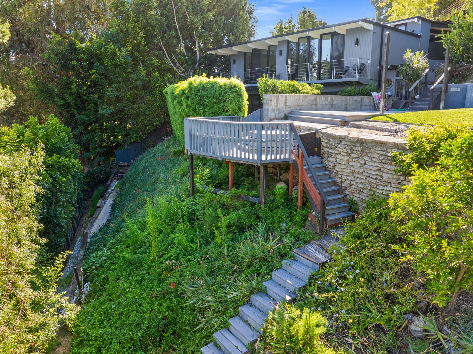 The inclusion of the neighboring double lot further separates the property from surrounding homes, creating additional buffer space rarely found in the Hollywood Dell. 