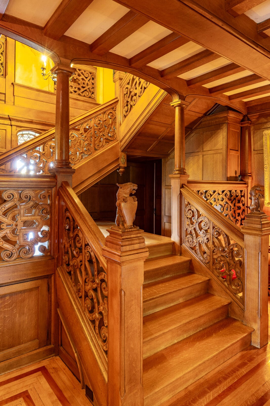 A hand-carved oak staircase serves as the centerpiece of the home, featuring whimsical animal carvings and artisan detailing rarely found in modern construction.