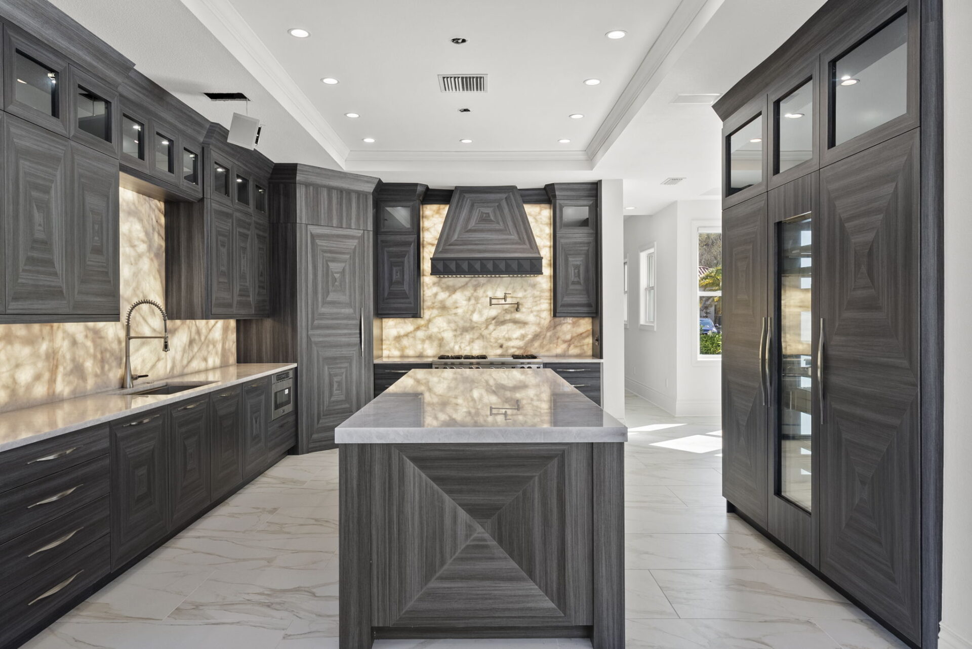 Dark custom cabinetry creates a striking contrast against the bright interior, with geometric wood grain patterns adding texture throughout.