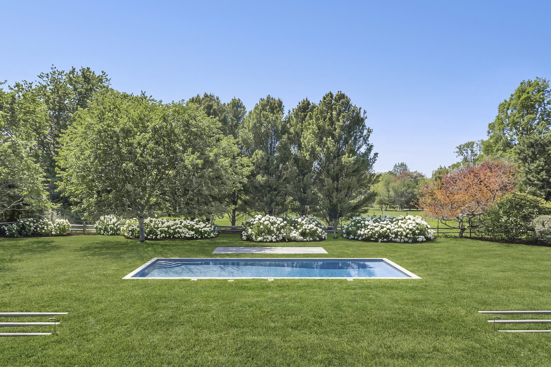 An expansive lawn that extends around an oversized heated gunite pool.
