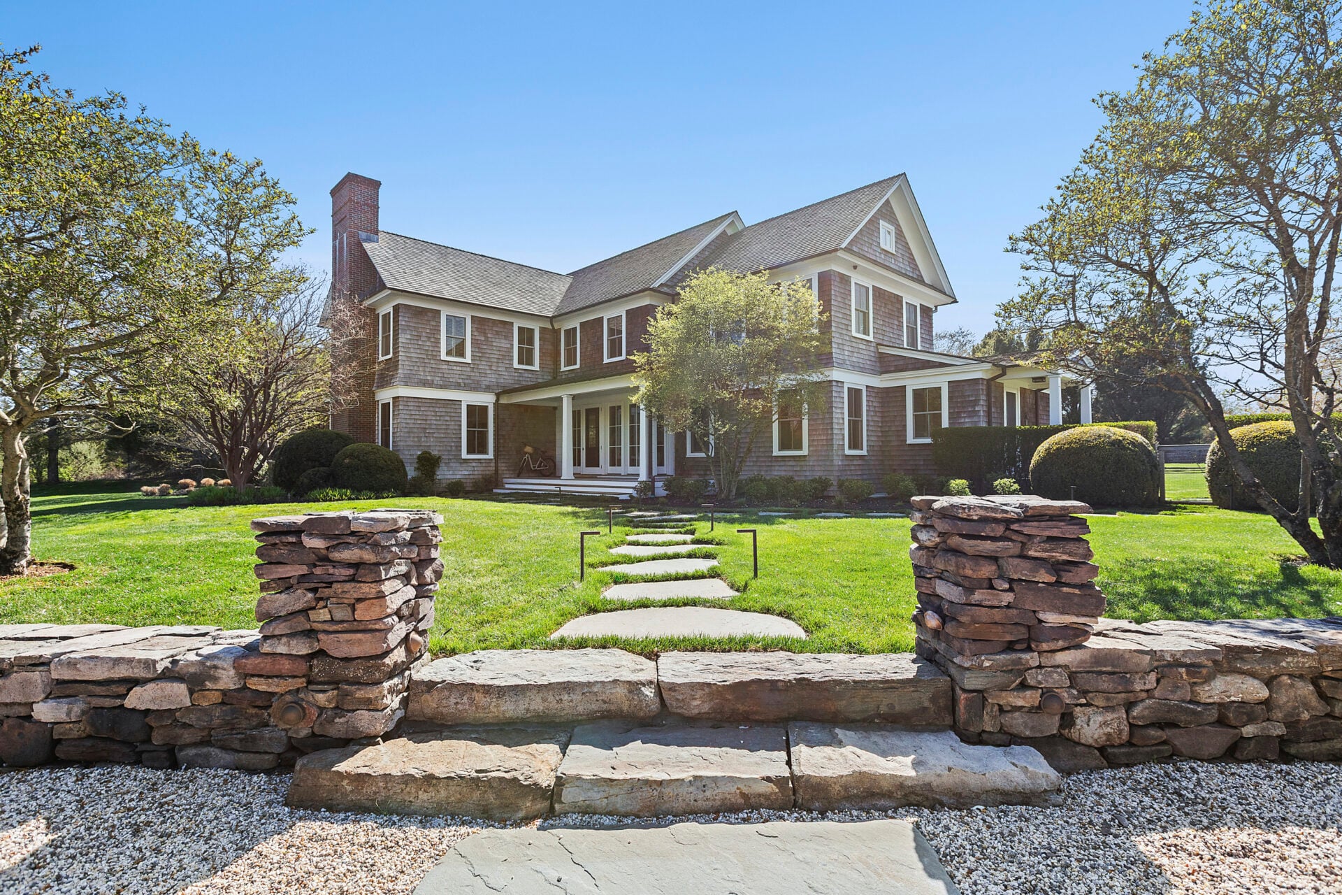 Once you reach the end of the private drive, the house opens up with timeless Hamptons architecture, surrounded by an abundance of green space and perfectly paved walkways.