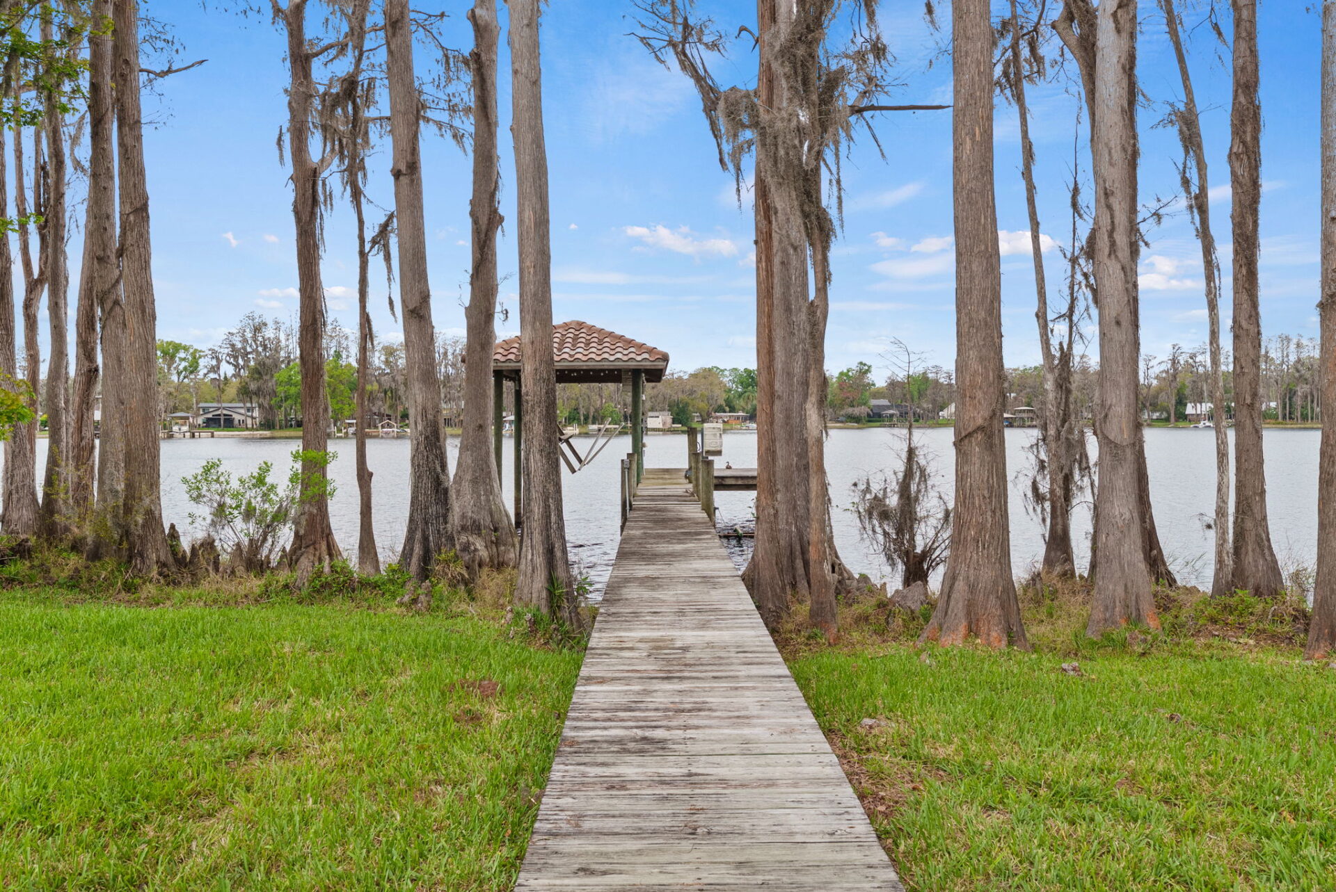 Extending from the shoreline, a private dock with a covered boat lift provides direct access to the ski-sized lake.