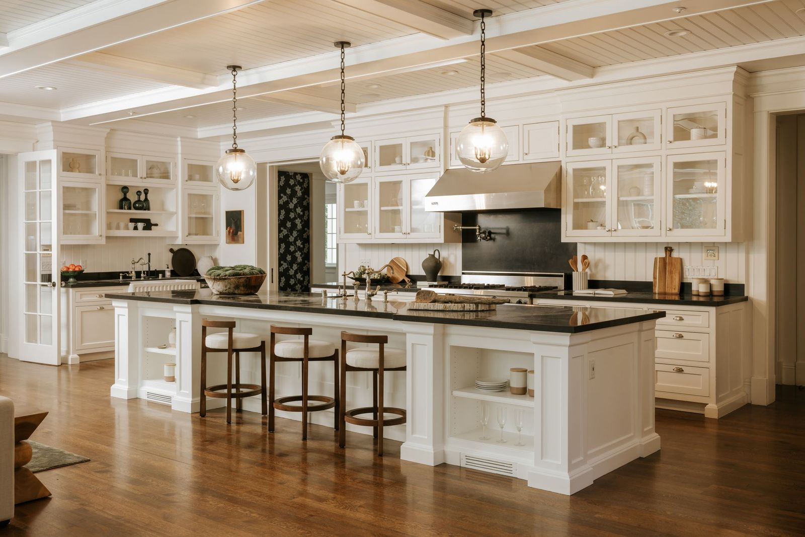 Behind the family room, the kitchen serves as the heart of the home, centered around a large island topped with dark stone countertops.