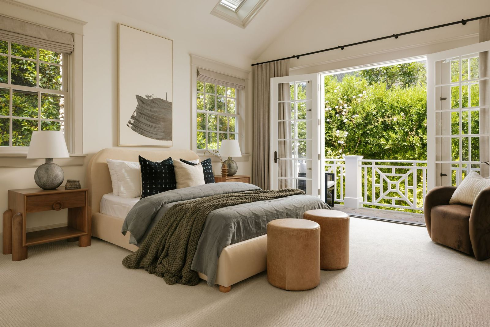 The first bedroom we want to highlight features vaulted ceilings, a skylight, and French doors that open directly to a private balcony. 