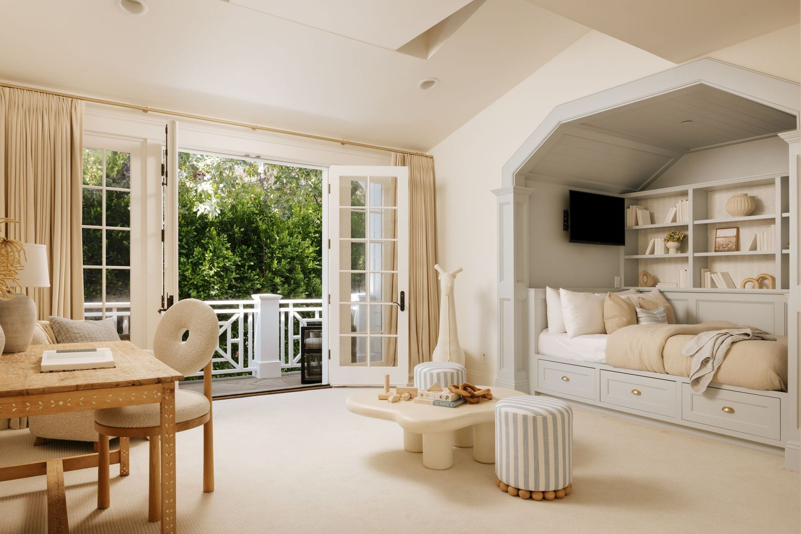 Designed with flexibility in mind, this bedroom incorporates a built-in sleeping nook framed by custom millwork, shelving, and storage drawers below. 