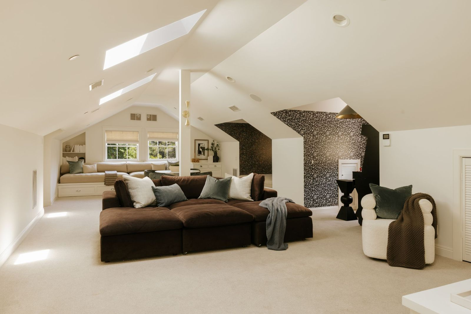 Tucked beneath the roofline, the bonus room offers an expansive open layout illuminated by multiple skylights and dormer windows. 