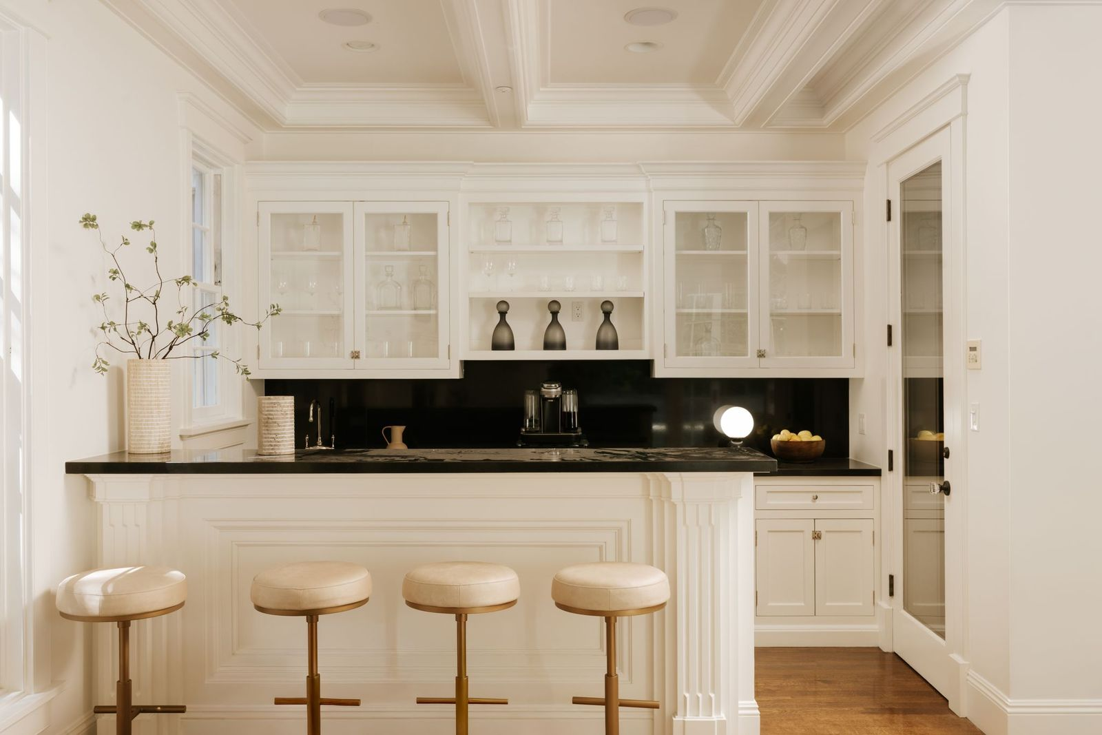 Designed in the same style, the bar is equipped with its own sink, display shelving, and storage for glassware, making it well suited for hosting guests without disrupting activity in the main kitchen.