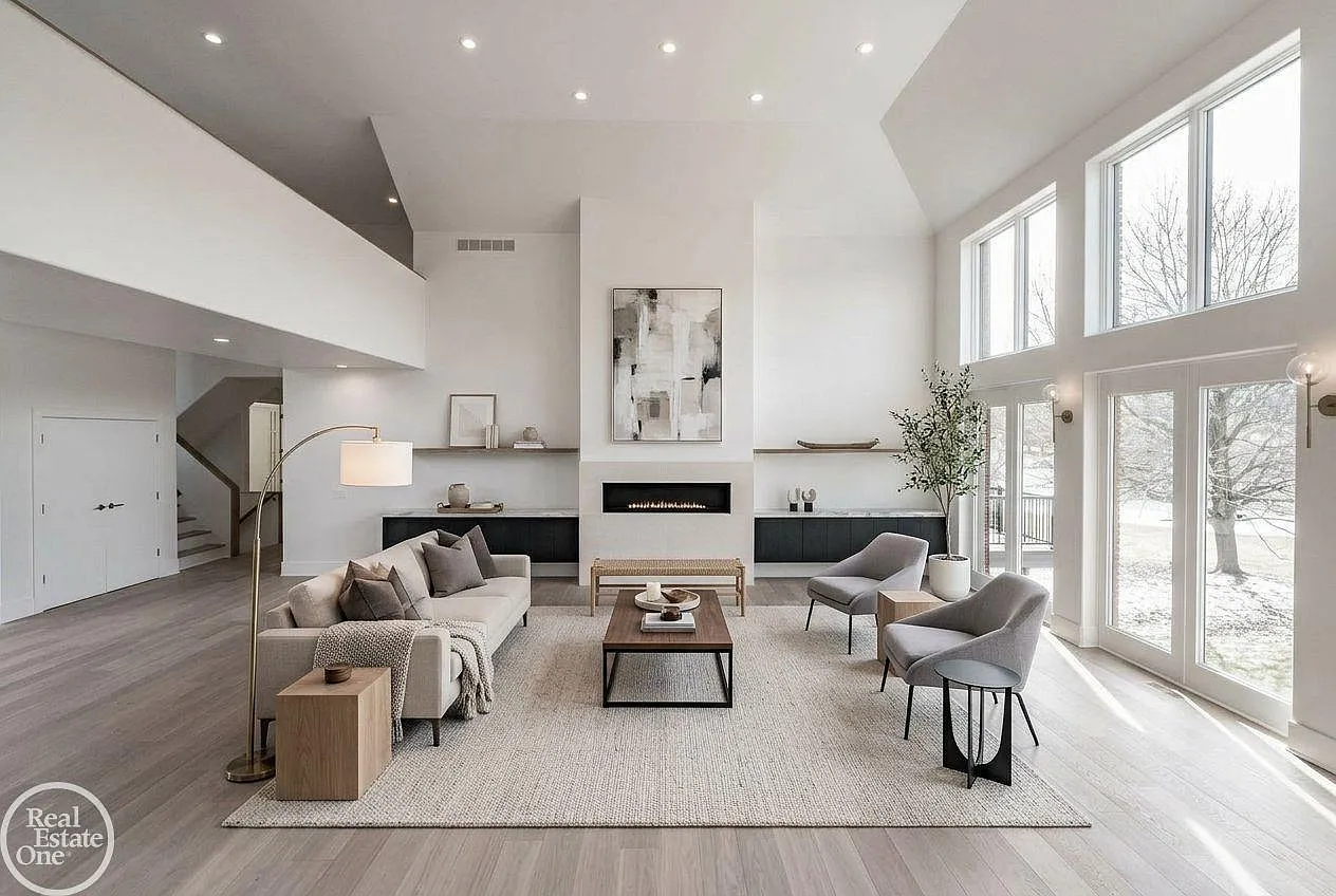 In the center of the room, a sleek linear fireplace is framed by built-in cabinetry and floating display shelves that stretch across the feature wall.