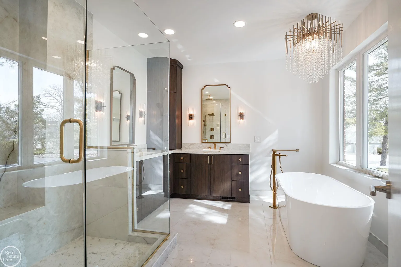 The connected bathroom is finished with large-format marble surfaces, creating a bright and polished atmosphere. 
