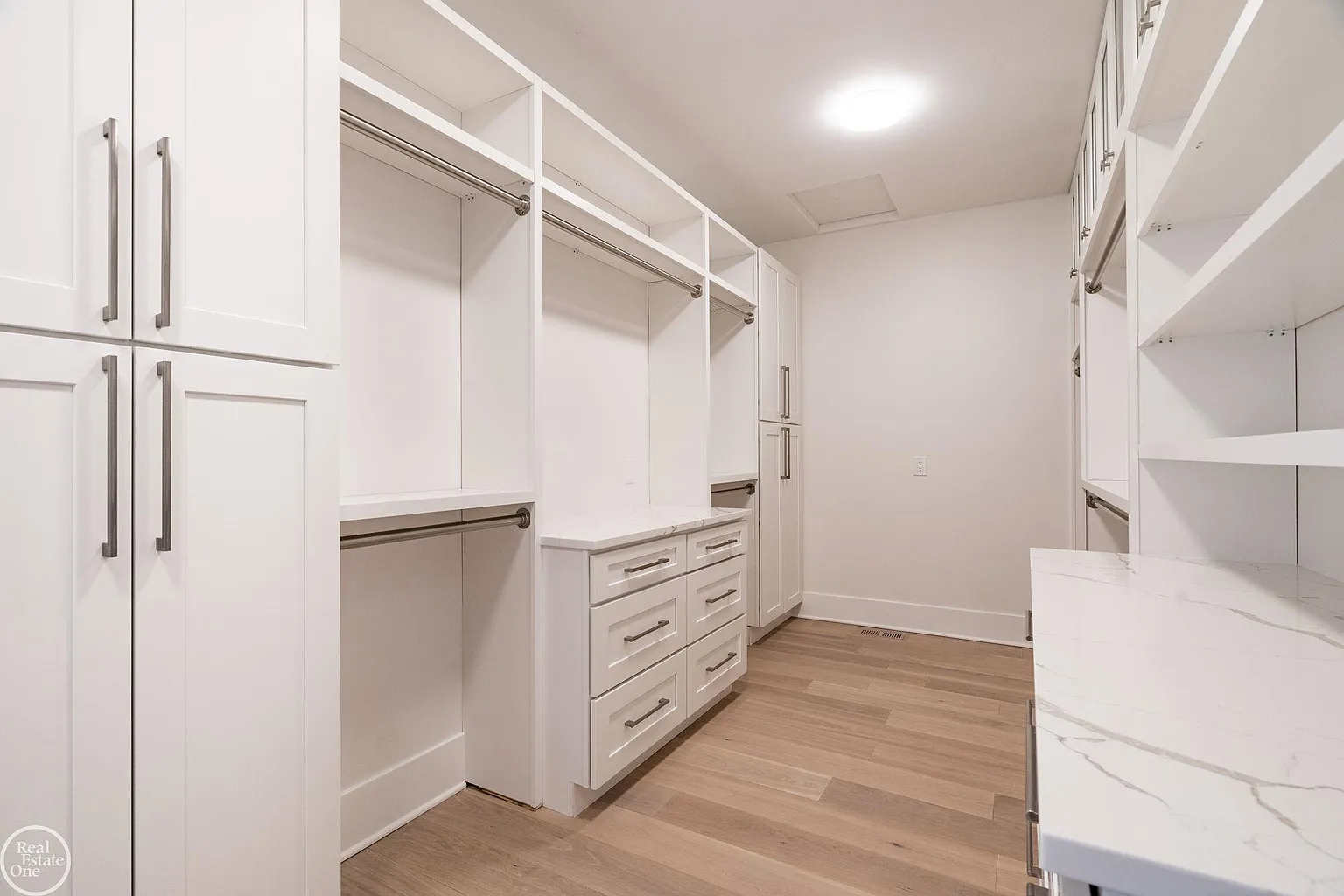 The suite is completed by a large walk-in closet where custom built-ins aline both sides of the room offering extensive hanging racks, drawer storage, and countertops for displaying your favorite items.
