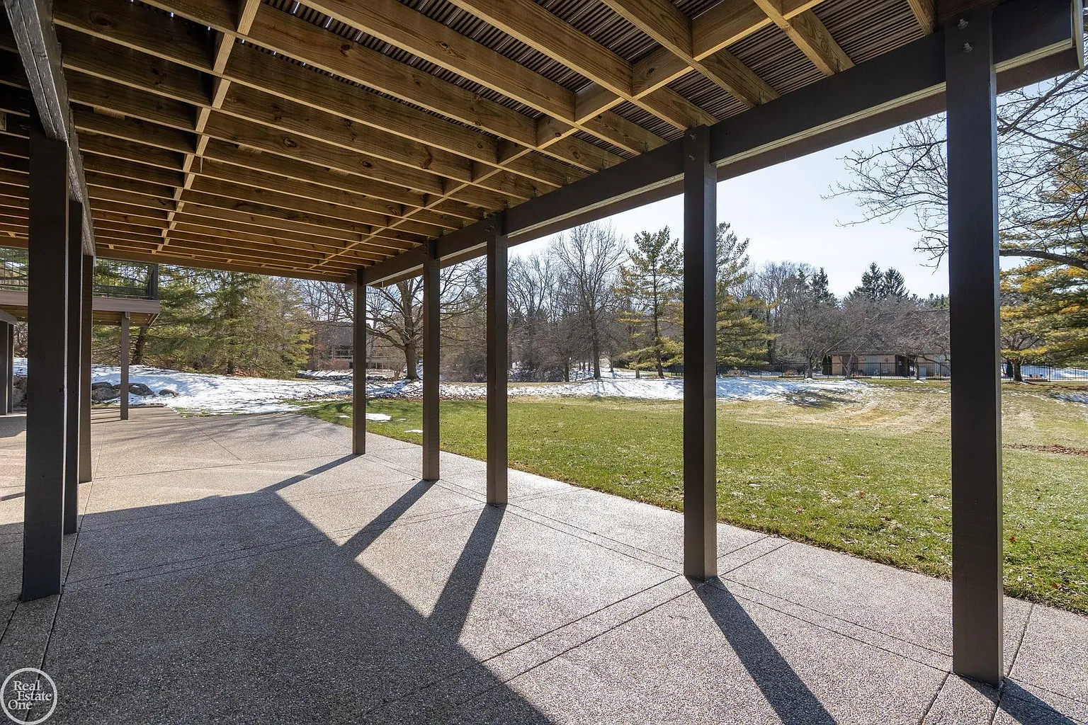 Below, a covered walkout patio sits directly beneath the deck, creating a second outdoor living area connected to the lower level. 
