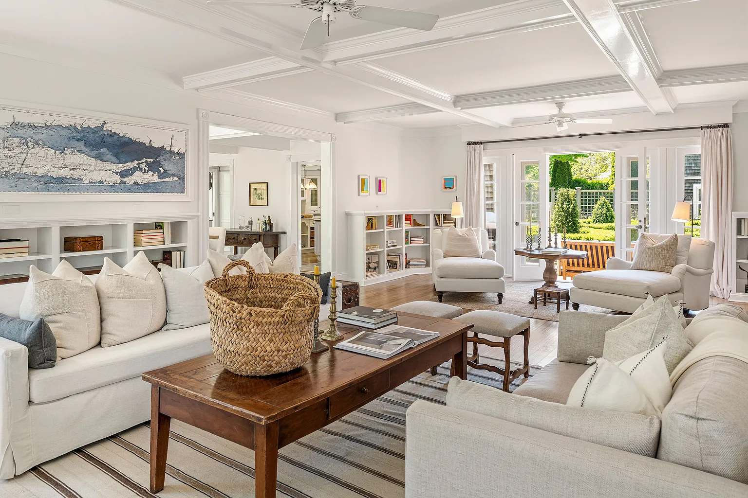 Stepping into the main living room, the home opens into a series of inviting gathering spaces beneath coffered ceilings.