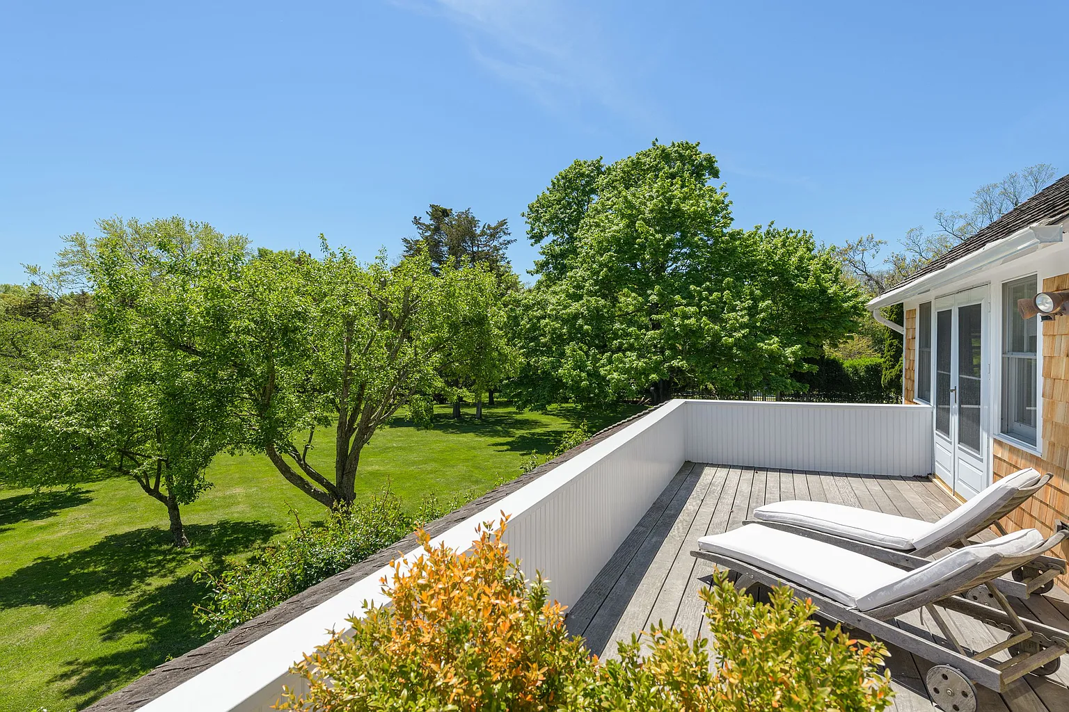 French doors open from the suite onto a private balcony overlooking the gardens and orchard-like lawns.