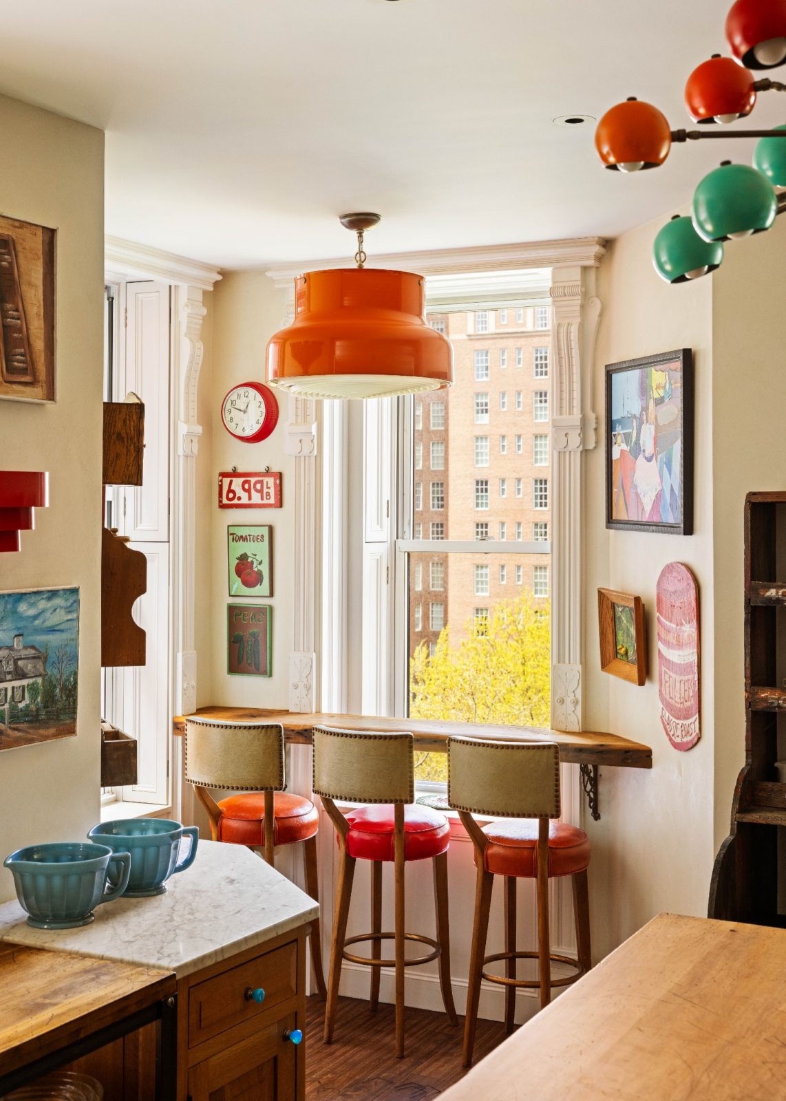Artwork, decorative shelving, and collected objects are integrated throughout, giving the space the character of a lived-in creative studio rather than a conventional luxury kitchen.