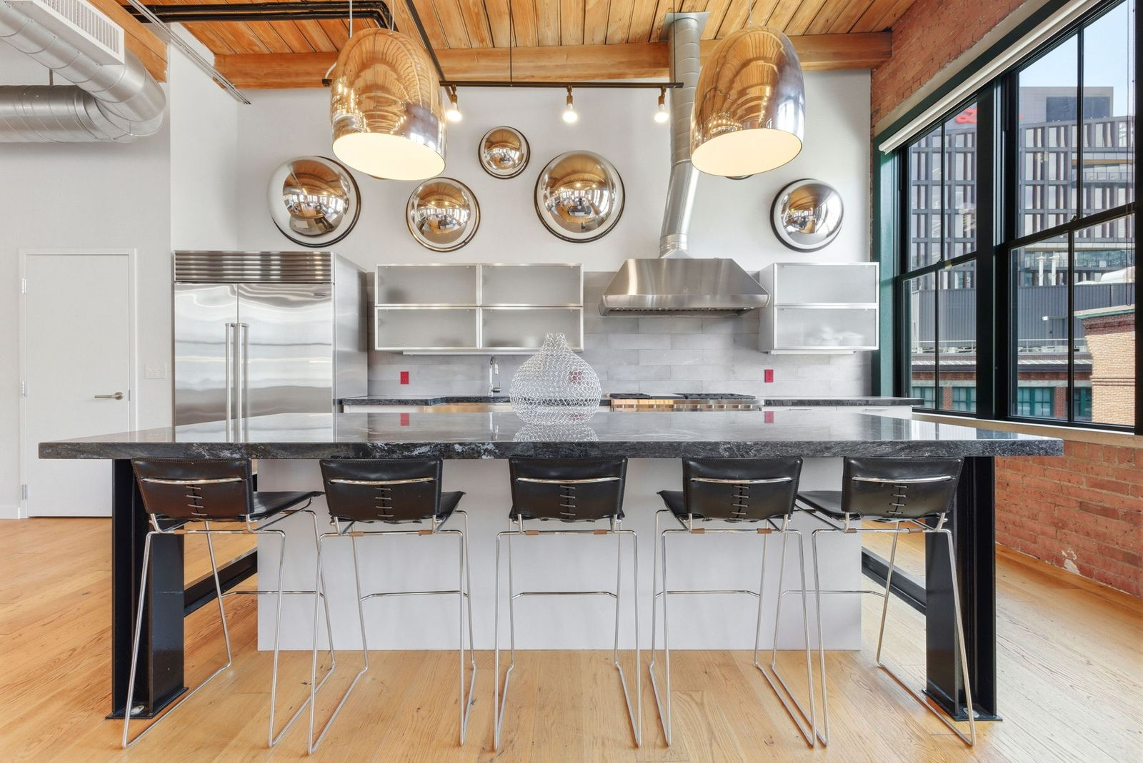 A substantial island anchors the workspace, providing seating for casual dining while creating a natural connection between the kitchen, dining area, and living spaces.