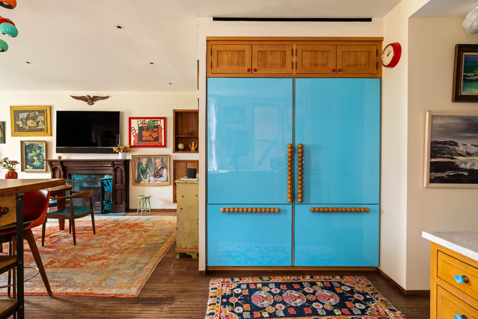 One of the room’s most distinctive features is the custom-painted refrigerator, which was intentionally designed to blend into the surrounding cabinetry instead of standing apart as a standard appliance.