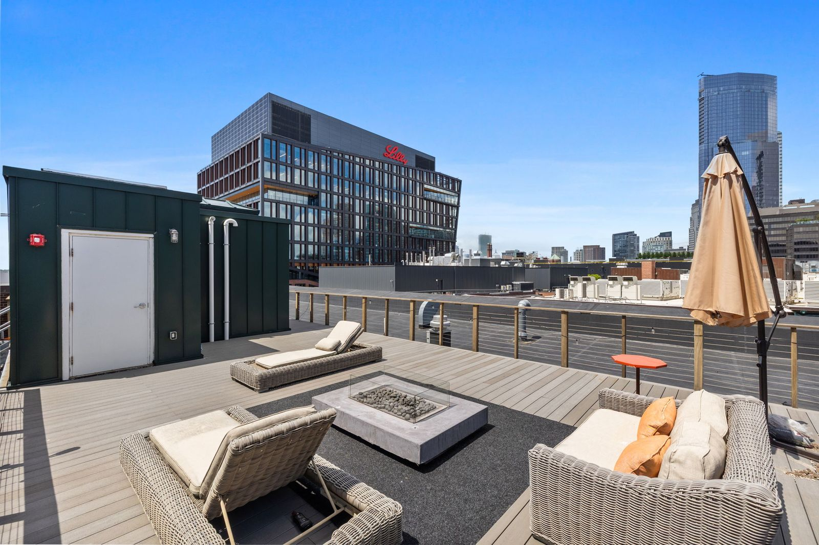 The deck itself has been arranged as an outdoor living room, with lounge seating gathered around a fire pit at its center.