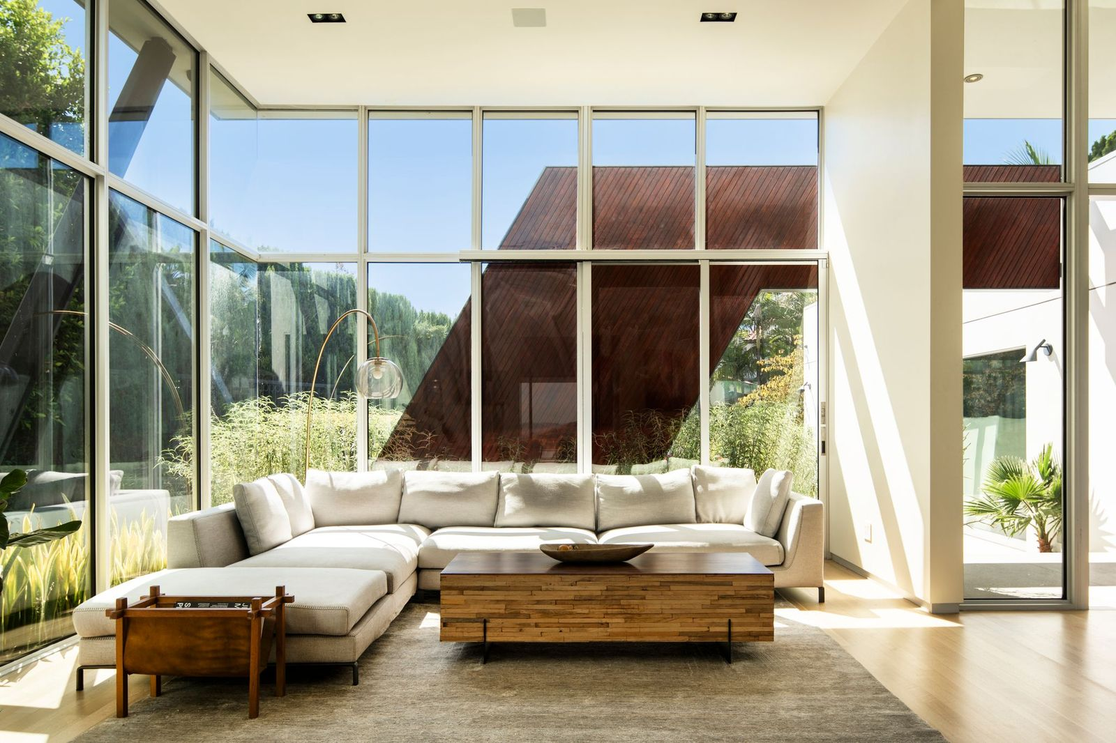The room features a large sectional positioned beneath the soaring ceiling, creating a casual seating area within the home's most architecturally striking space.