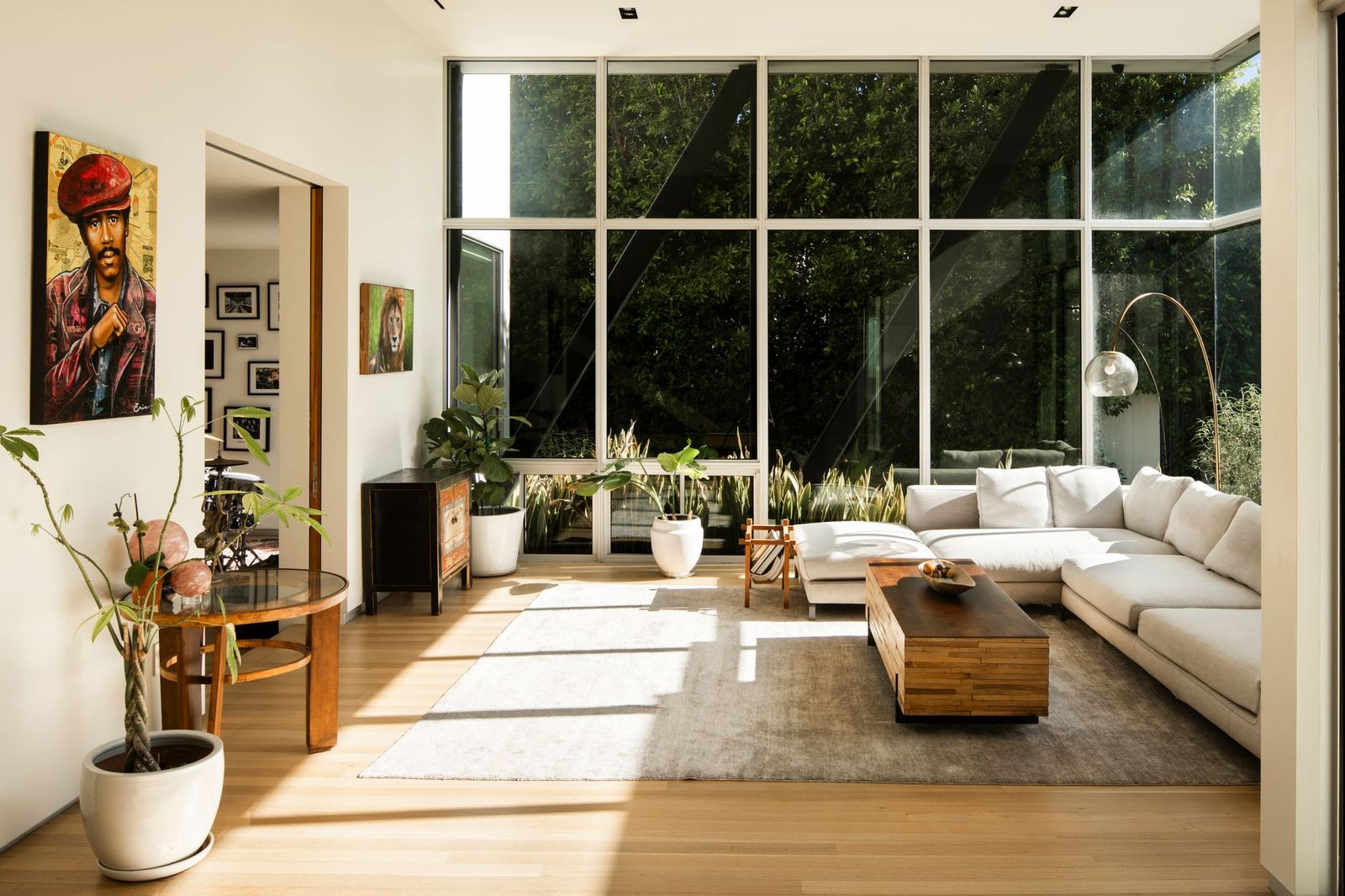 Floor-to-ceiling walls of glass rise nearly the full height of the room, surrounding the space with views of the landscaped courtyard.