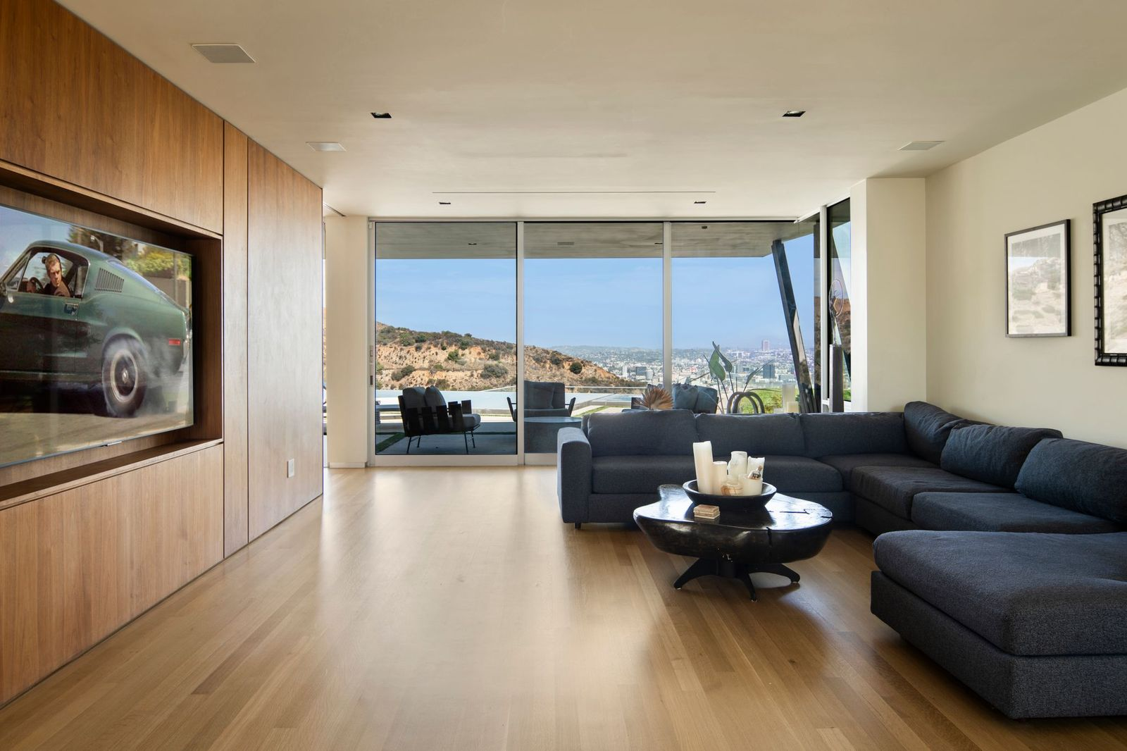 On the opposite side of the custom cabinetry is a dedicated media lounge featuring a large sectional positioned to face a built-in television wall.