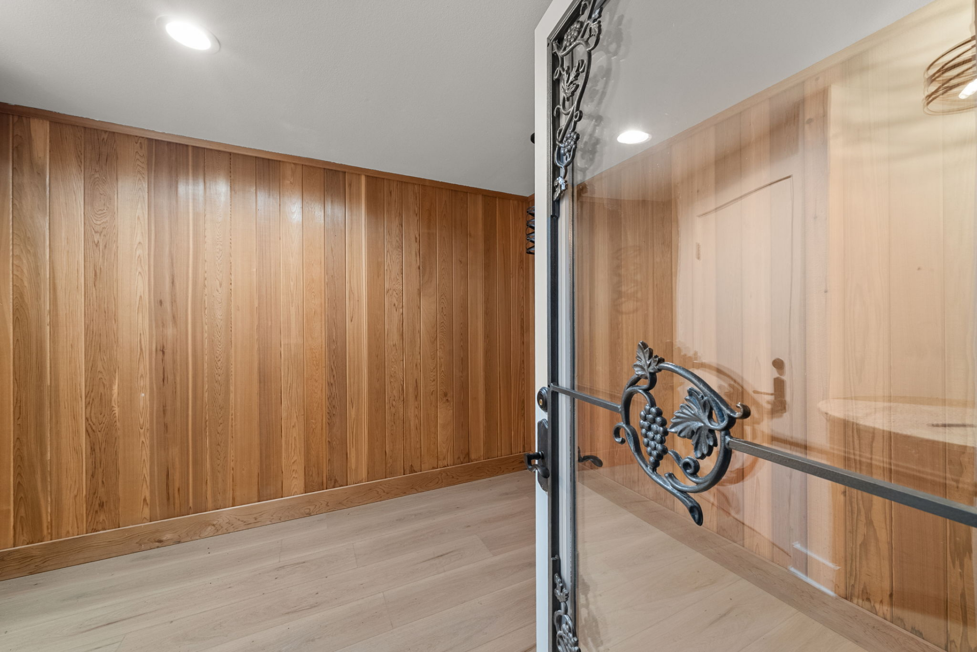 Wood-paneled walls and a private enclosed layout create an ideal setting for wine storage and display.