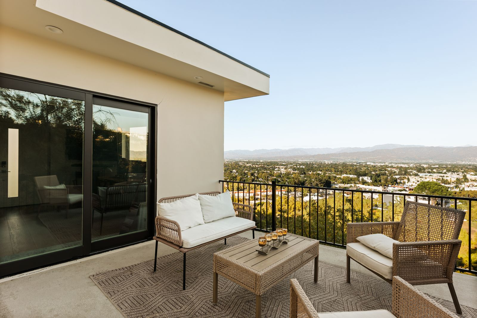 Sliding glass doors open directly onto a private viewing deck positioned high above the surrounding neighborhood. 